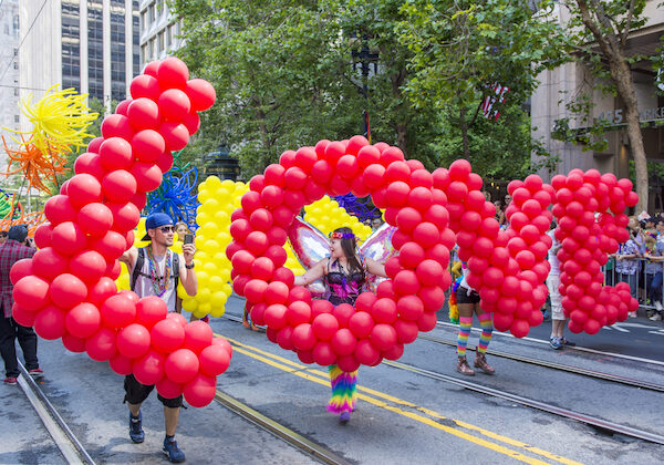Pride Parade Marchers holding Love Balloons
